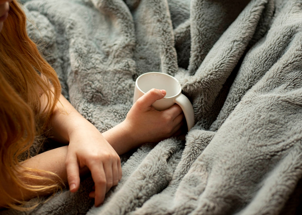 Frau mit Gewichtsdecke und Tasse