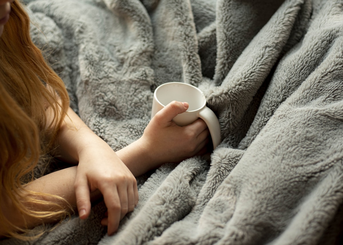 Frau mit Gewichtsdecke und Tasse