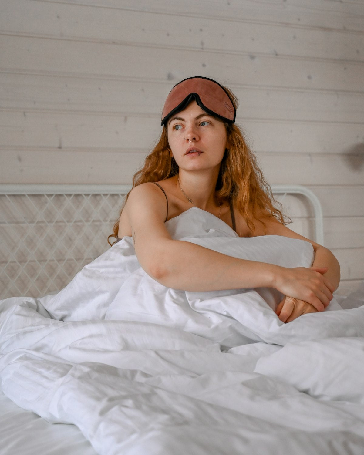 Frau liegt im Bett mit Maske