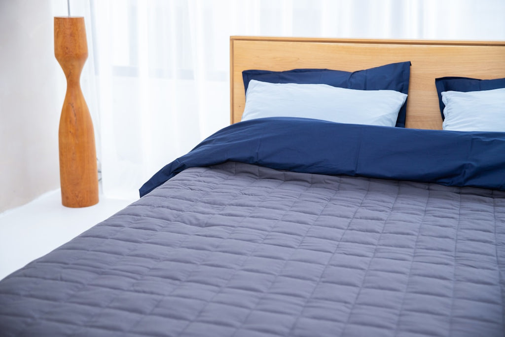 Bett mit blauer Gewichtsdecke
