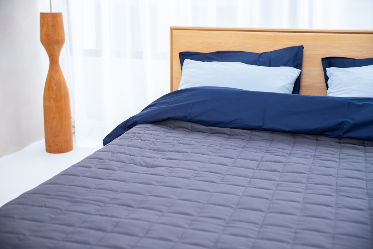 Bett mit blauer Gewichtsdecke