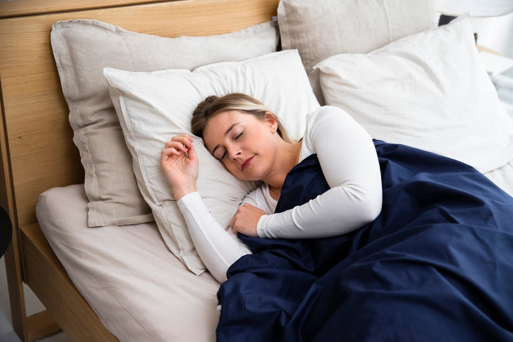Frau schläft mit blauer Decke